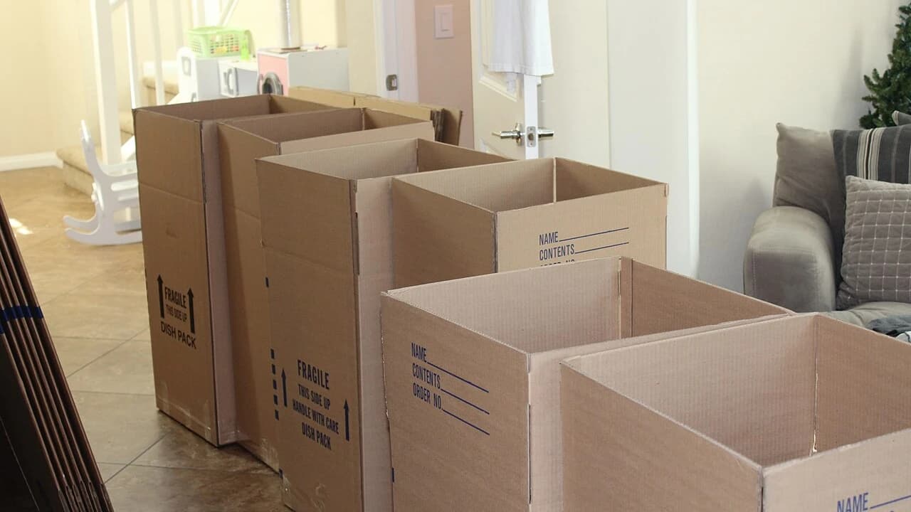 Kardus pindahan terbuka berjajar di dalam rumah